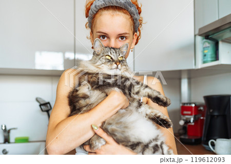 portrait red-haired teenage girl with gray fluffy cat 119612093
