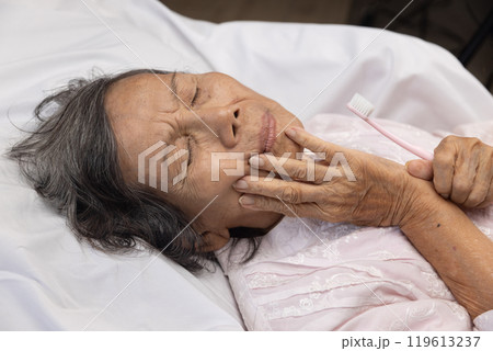 Elderly woman put hand on jaw because toothache. 119613237