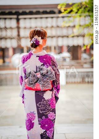 Woman in Kimono Walking Towards Shrine with a flower on her head. Kyoto Japan. Japanese traditional architecture background. Woman in Kimono Walking Towards Shrine with a flower on her head. Kyoto Japan. Japanese traditional architecture background. 119613257