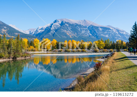 People are walking along the Bow River riverside trail in autumn. Canmore, Alberta, Canada. Rundle Plante Lane. People are walking along the Bow River riverside trail in autumn. Canmore, Alberta, Canada. Rundle Plante Lane. 119613272