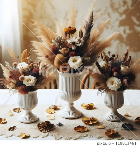 Dried and fresh flowers in a white ceramic vase. 119613461