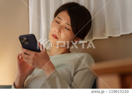 スマホを使いながら寝落ちする女性 スマホを使いながら寝落ちする女性 119615220