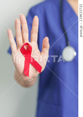 Doctor with Red Ribbon for December World Aids Day, acquired immune deficiency syndrome, multiple myeloma Cancer Awareness month and National Red ribbon week. Healthcare and world cancer day concept 119615732