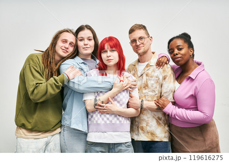 Portrait of group of friends from diverse backgrounds smiling and hugging each other in casual attire against plain white background emanating warmth and camaraderie Portrait of group of friends from diverse backgrounds smiling and hugging each other in casual attire against plain white background emanating warmth and camaraderie 119616275