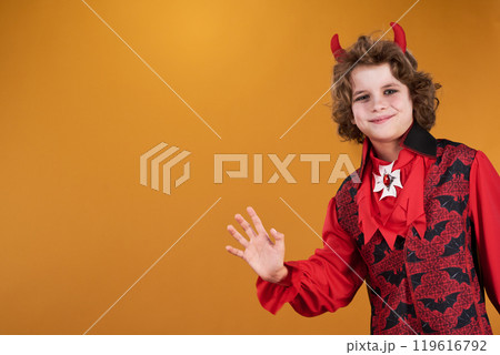Smiling boy in costume waving hand Smiling boy in costume waving hand 119616792