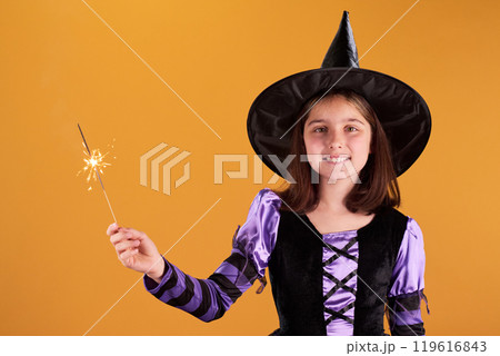 Smiling witch with burning sparkler 119616843