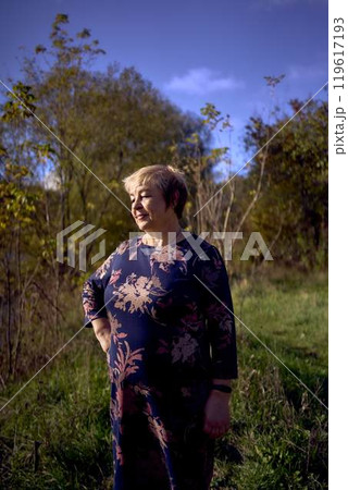 a portrait of an elderly woman with gray hair in a dress in the autumn forest a portrait of an elderly woman with gray hair in a dress in the autumn forest 119617193