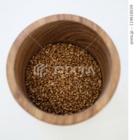 Wooden bowl filled with dried grains, minimalist rustic food photography with natural textures 119618039