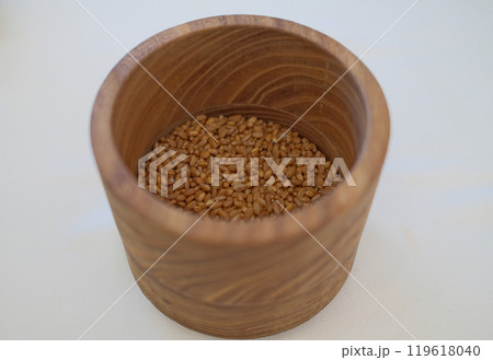 Wooden bowl filled with dried grains, minimalist rustic food photography with natural textures 119618040
