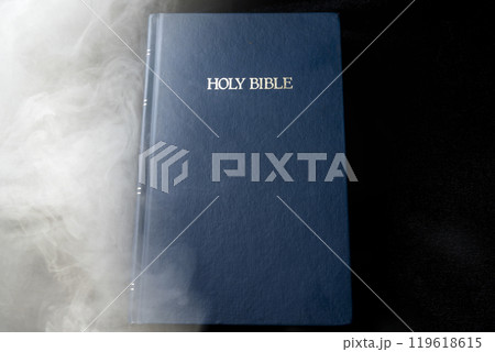 Book of Holy Bible. It is laying with smoke background. Symbol of faith and worship in God 119618615