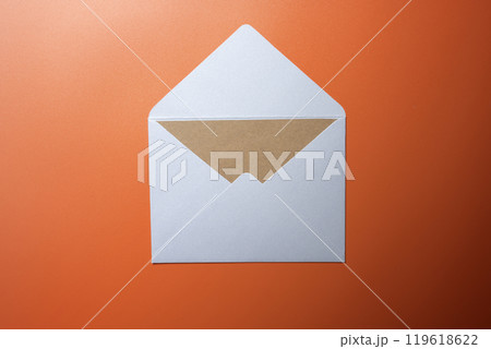 Top view of white envelope and postcard with empty blank brown card on colored background 119618622