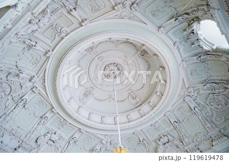 ornate ceiling features intricate carvings, detailing, highlighted by central chandelier, showcasing stunning craftsmanship in ceiling of main staircase ornate ceiling features intricate carvings, detailing, highlighted by central chandelier, showcasing stunning craftsmanship in ceiling of main staircase 119619478