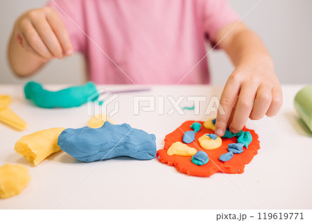 A child creates colorful shapes with play dough during an arts and crafts activity at home 119619771