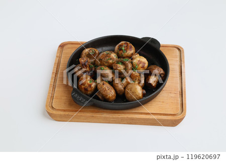 Grilled mushrooms with spices on a pan. Top view of brown champignon on pan on white background. Homemade food, healthy eating Grilled mushrooms with spices on a pan. Top view of brown champignon on pan on white background. Homemade food, healthy eating 119620697