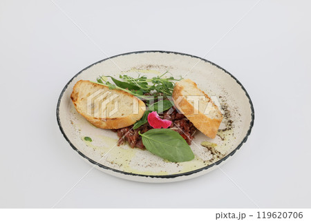 Veal tartare with dry wheat bread on a white plate on a white background Veal tartare with dry wheat bread on a white plate on a white background 119620706