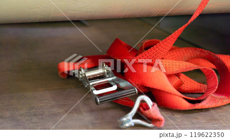 A lashing strap thrown onto the floor of the truck body 119622350