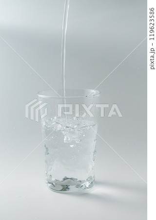 シンプルなガラスコップに水を注ぐ シンプルなガラスコップに水を注ぐ 119623586