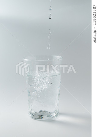 シンプルなガラスコップに水を注ぐ 119623587
