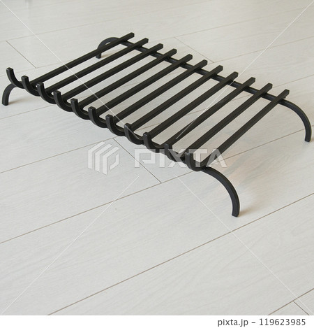 An object photo shoot of black grilles for fireplaces on a light background in the interior. 119623985