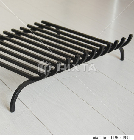 An object photo shoot of black grilles for fireplaces on a light background in the interior. 119623992