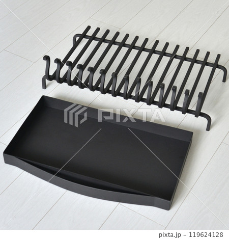 An object photo shoot of black grilles for fireplaces on a light background in the interior. An object photo shoot of black grilles for fireplaces on a light background in the interior. 119624128