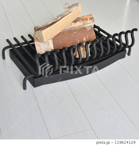 An object photo shoot of black grilles for fireplaces on a light background in the interior. An object photo shoot of black grilles for fireplaces on a light background in the interior. 119624129
