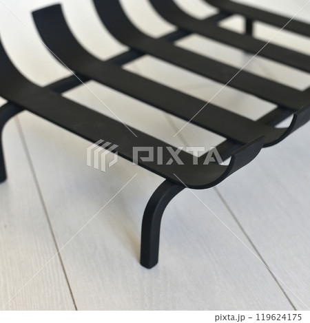 An object photo shoot of black grilles for fireplaces on a light background in the interior. An object photo shoot of black grilles for fireplaces on a light background in the interior. 119624175