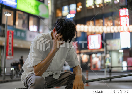 路上で頭を抱える男性 119625127