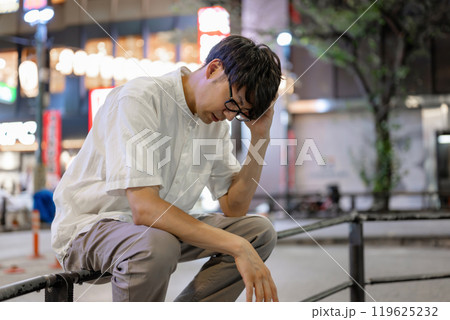 街で考え事をする男性 119625232