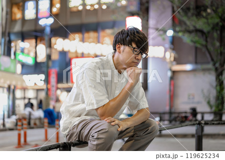 街で考え事をする男性 119625234