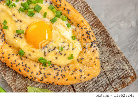 Khachapuri with egg on wooden background. Georgian cuisine. top view. copy space for text Khachapuri with egg on wooden background. Georgian cuisine. top view. copy space for text 119625243