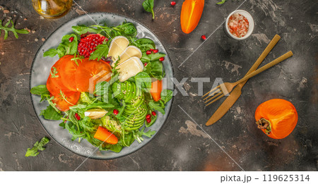 Persimmon salad with fresh greens, avocado, Camembert cheese and pomegranate 119625314