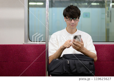 電車に乗る男性　スマホ　音楽 119625627