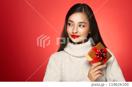Beautiful woman in a white knitted sweater with gift box Beautiful woman in a white knitted sweater with gift box 119626100