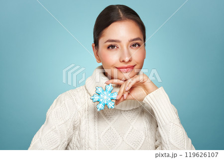 Woman in a white knitted sweater with cookie Snowflake 119626107