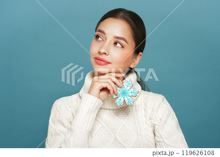 Woman in a white knitted sweater with cookie Snowflake Woman in a white knitted sweater with cookie Snowflake 119626108