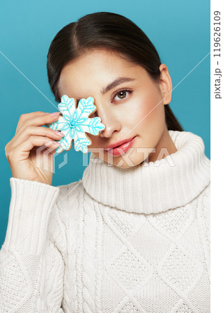 Woman in a white knitted sweater with cookie Snowflake Woman in a white knitted sweater with cookie Snowflake 119626109