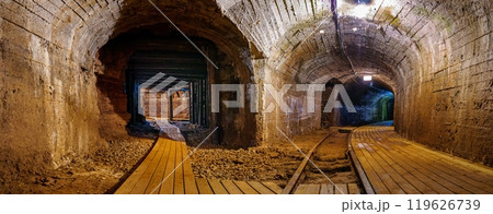 Old underground mine tunnel with wooden walkways and arched stone walls, cooper mine 119626739