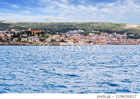 Scenic view of a Mediterranean coastal town with red-tiled roofs and a blue sea. 119626817