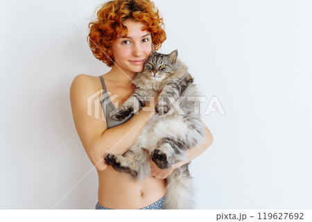 portrait red-haired teenage girl with gray fluffy cat portrait red-haired teenage girl with gray fluffy cat 119627692