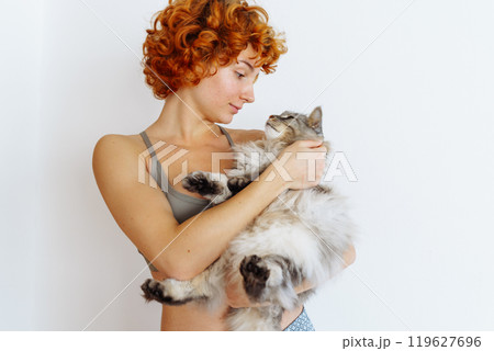 portrait red-haired teenage girl with gray fluffy cat 119627696