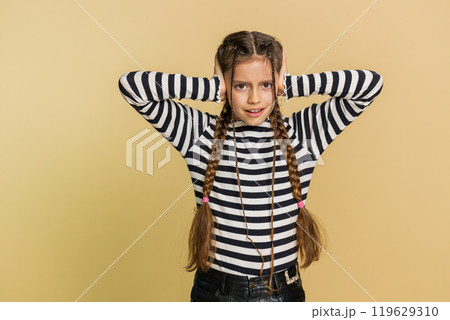 Frustrated young school girl kid covering ears ignoring unpleasant noise loud voices avoiding advice Frustrated young school girl kid covering ears ignoring unpleasant noise loud voices avoiding advice 119629310