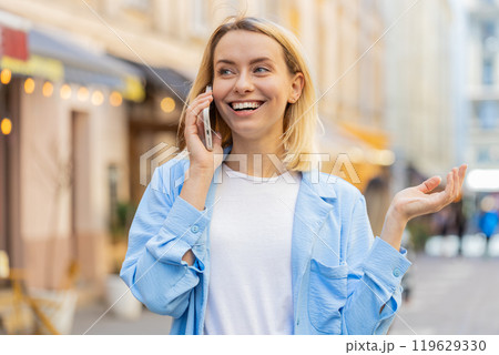 Woman tourist having remote conversation communicate speaking by smartphone with friend good news Woman tourist having remote conversation communicate speaking by smartphone with friend good news 119629330