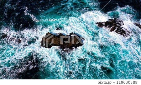 Stunning Aerial View of Vibrant Turquoise Waves Elegantly Crashing Against Rocky Shoreline Stunning Aerial View of Vibrant Turquoise Waves Elegantly Crashing Against Rocky Shoreline 119630589