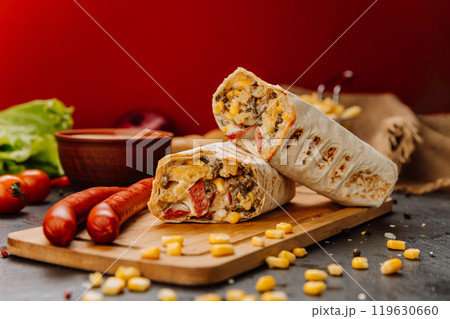Grilled wrap filled with sausage, corn, and melted cheese. Hearty meal or street food craving Grilled wrap filled with sausage, corn, and melted cheese. Hearty meal or street food craving 119630660