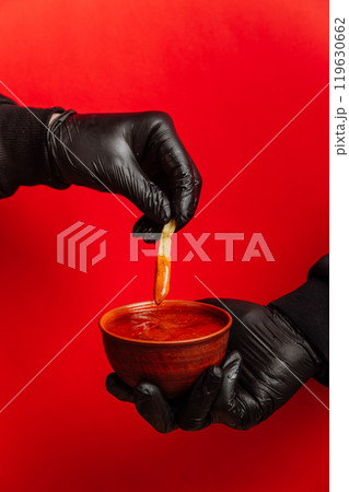 Crispy fries dipped in rich tomato sauce for a bold and appetizing fast food snack experience 119630662