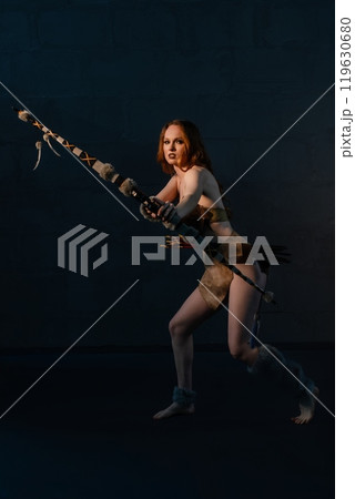 A warrior poised for action in a dramatic, shadowy studio environment A warrior poised for action in a dramatic, shadowy studio environment 119630680