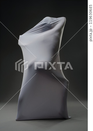 Abstract form draped in fabric creates intriguing shapes in low lighting Abstract form draped in fabric creates intriguing shapes in low lighting 119630685