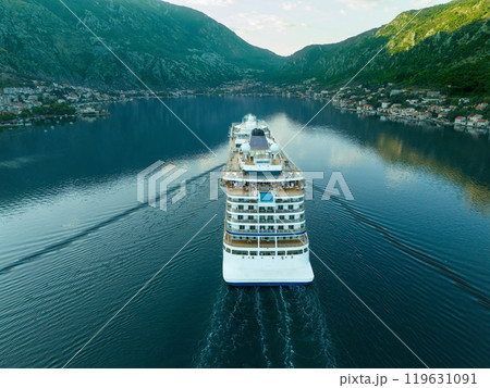 View of the stern of a cruise ship entering the bay at an anchorage for disembarking tourists View of the stern of a cruise ship entering the bay at an anchorage for disembarking tourists 119631091