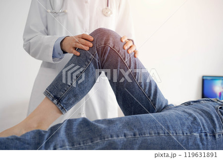 Doctor and patient are at the medical inspection in clinic. Orthopedic examines the knee of a young woman. Medicine concept 119631891